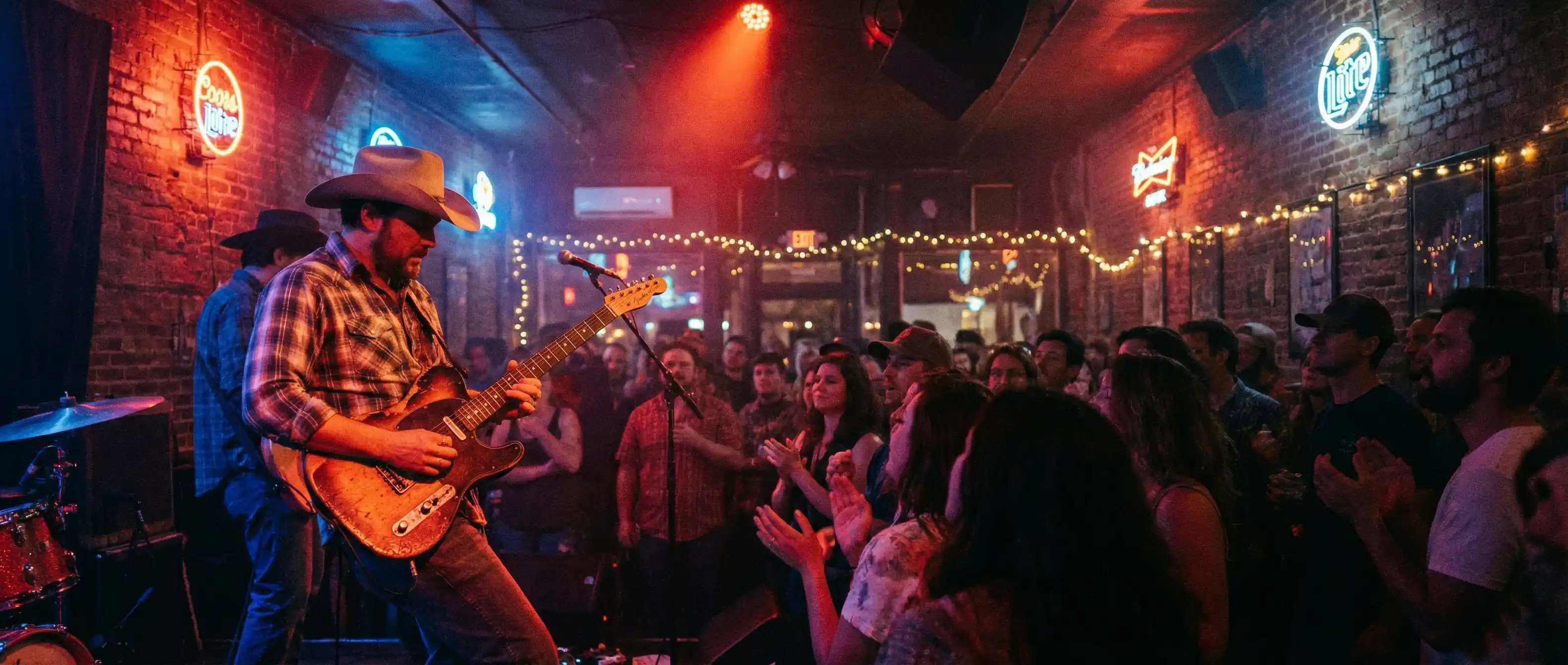 Live music performance at a Red River Cultural District venue in Austin Texas with neon signs and crowd