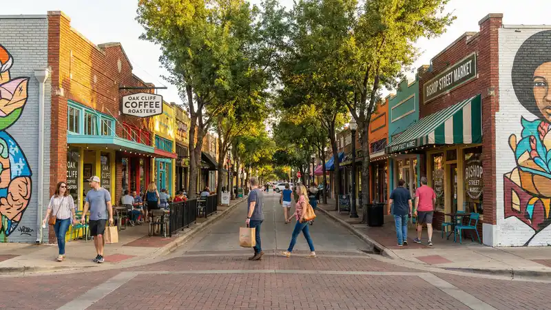 Walkable street in Bishop Arts District Dallas with colorful storefronts, murals, and pedestrians browsing local shops
